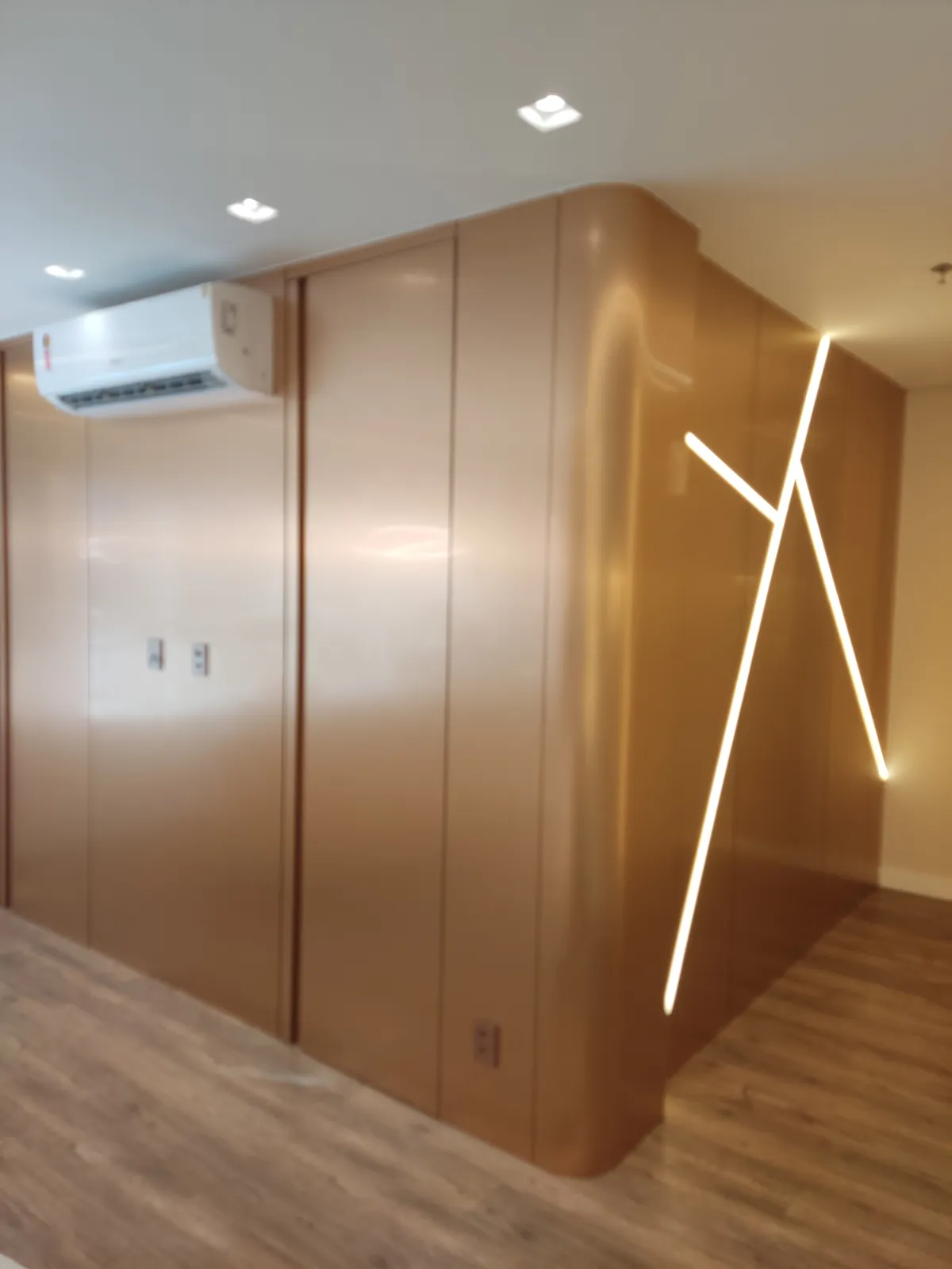 Recepção com painel curvo em madeira e LED